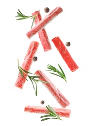 Image of Cut fresh crab sticks, rosemary and allspice falling on white background