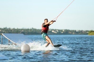 Photo of Man wakeboarding on river. Extreme water sport