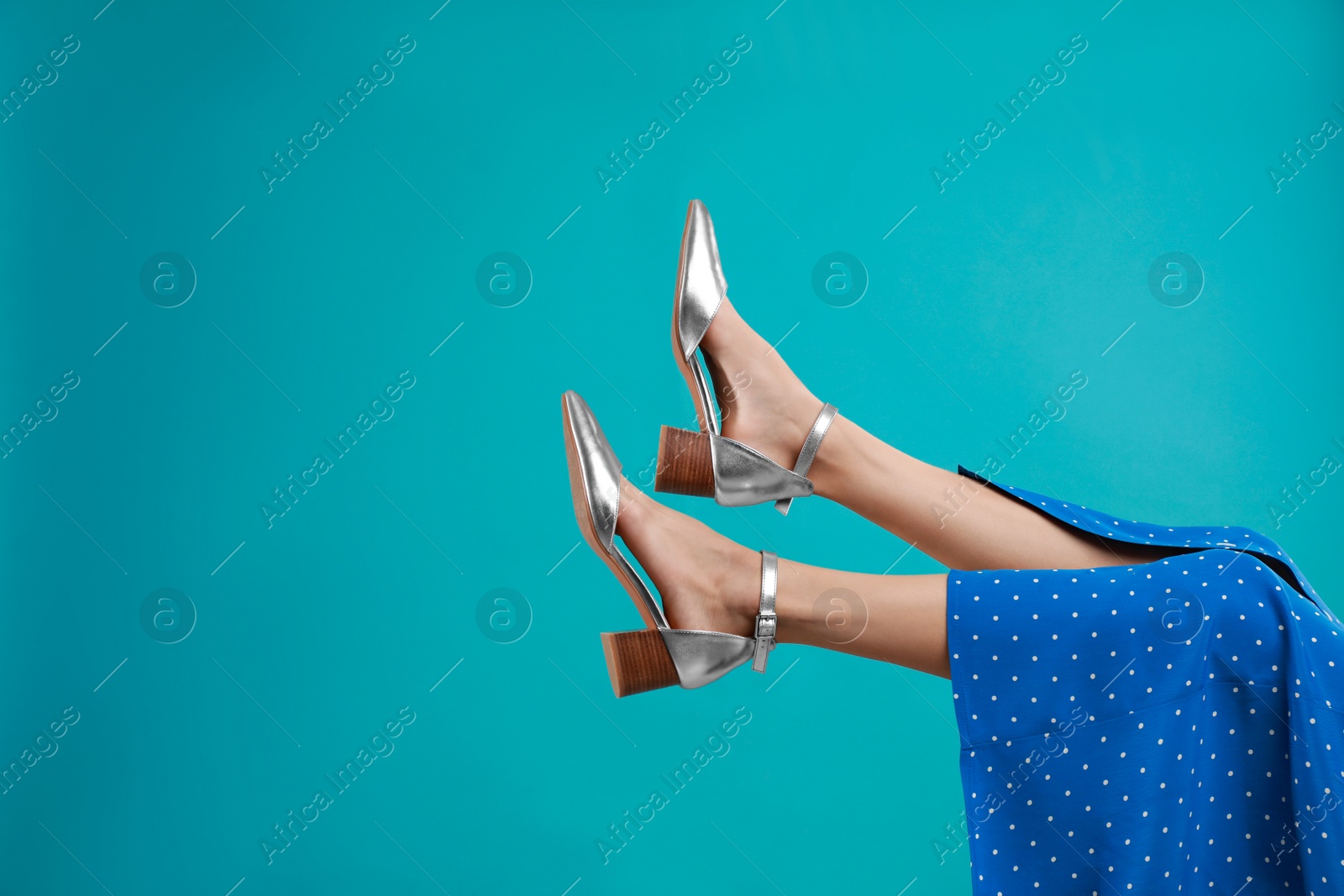 Photo of Woman in stylish shoes on light blue background. Space for text