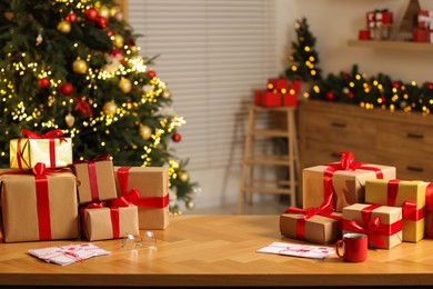 Photo of Many gift boxes and letters on table in room with Christmas decor, space for text