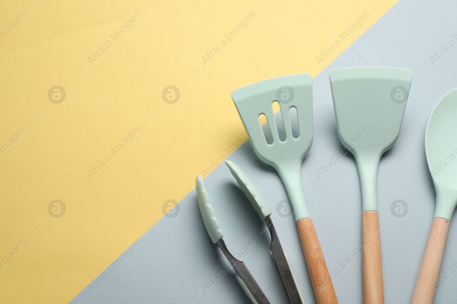 Photo of Different spatulas and tongs on color background, flat lay. Space for text