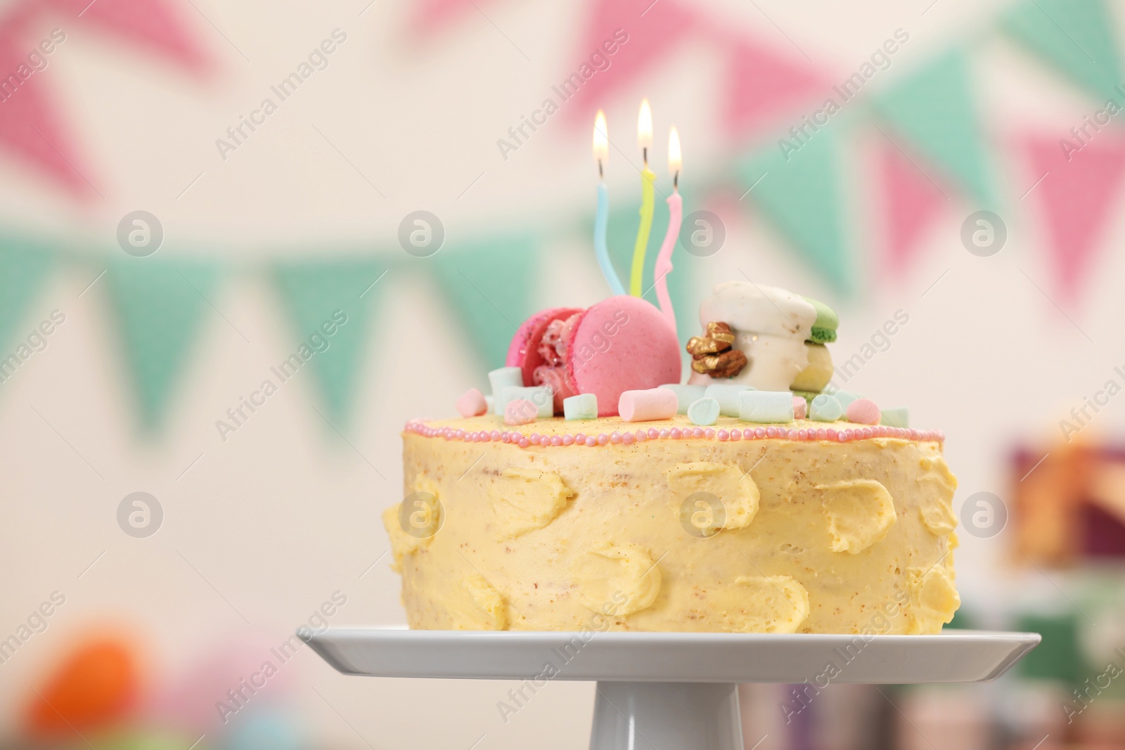 Photo of White stand with delicious cake decorated with macarons and marshmallows against blurred background, closeup