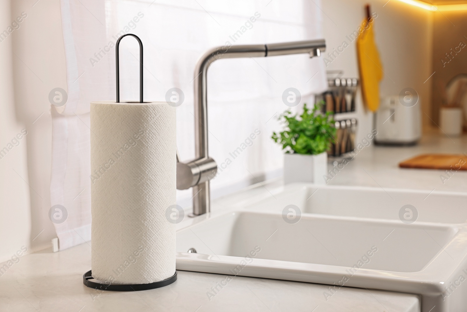 Photo of Roll of paper towels on white countertop in kitchen, space for text