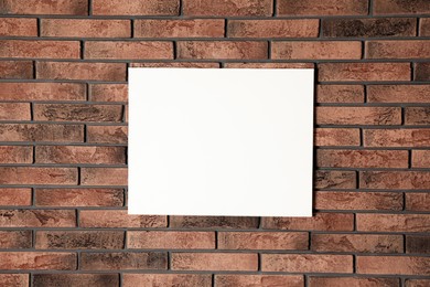 Photo of Blank canvas on brick wall. Space for design