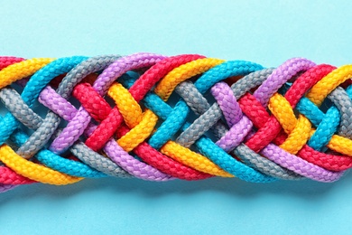 Photo of Braided ropes on color background, top view. Unity concept