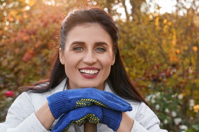 Photo of Woman wearing gloves and having rest after working in garden
