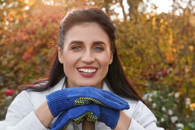 Woman wearing gloves and having rest after working in garden