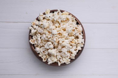 Tasty popcorn on white wooden table, top view