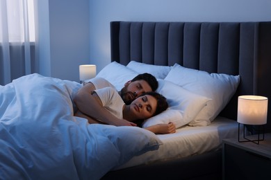 Photo of Lovely couple sleeping together in bed at night