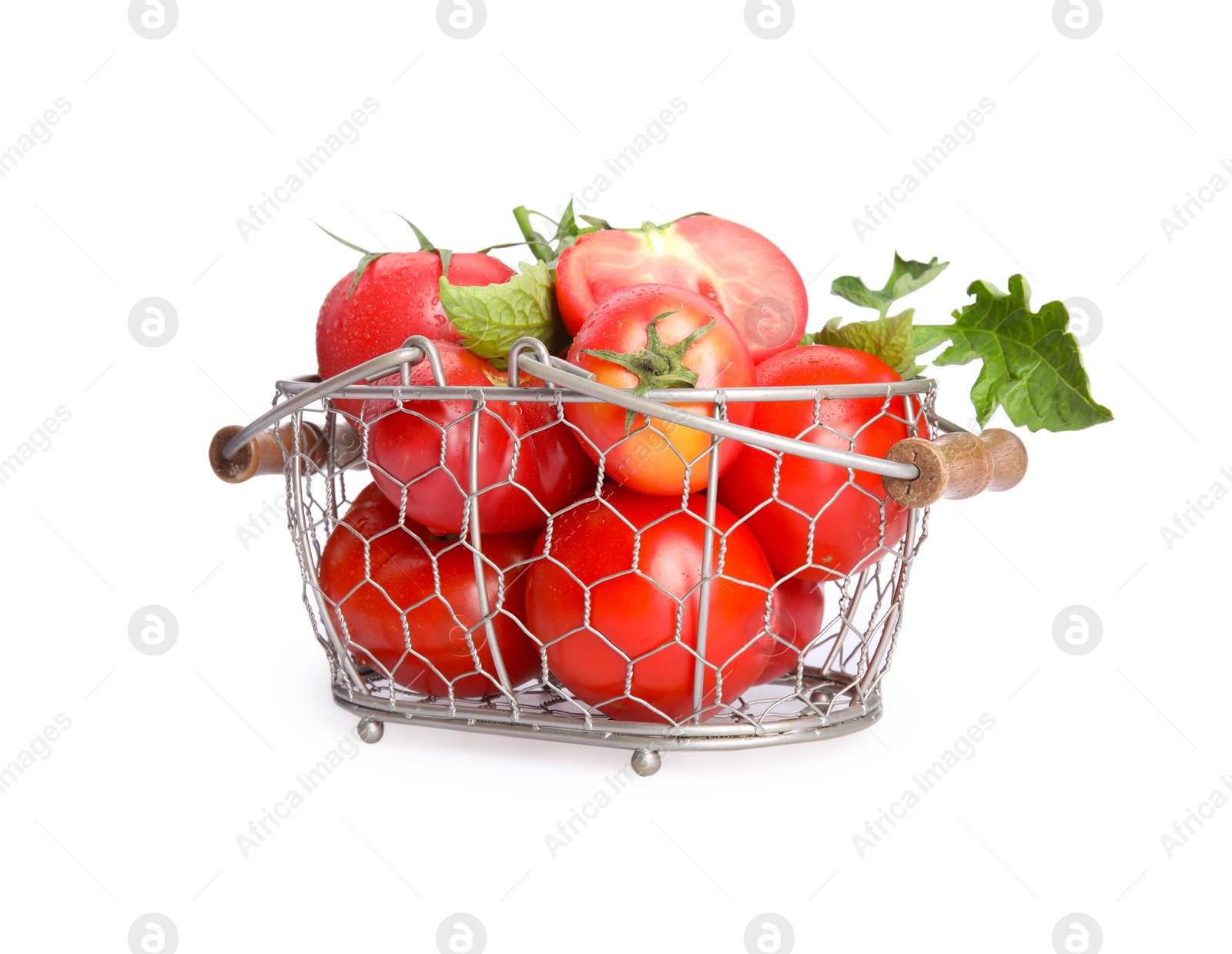 Photo of Many ripe tomatoes with leaves in metal basket on white background