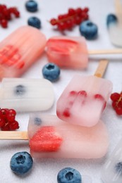 Tasty berry ice pops on light table, closeup