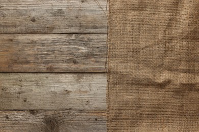 Burlap fabric on wooden table, top view. Space for text