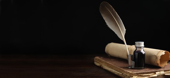 Quill, bottle of ink, old book and parchment scroll on wooden table, space for text. Banner design