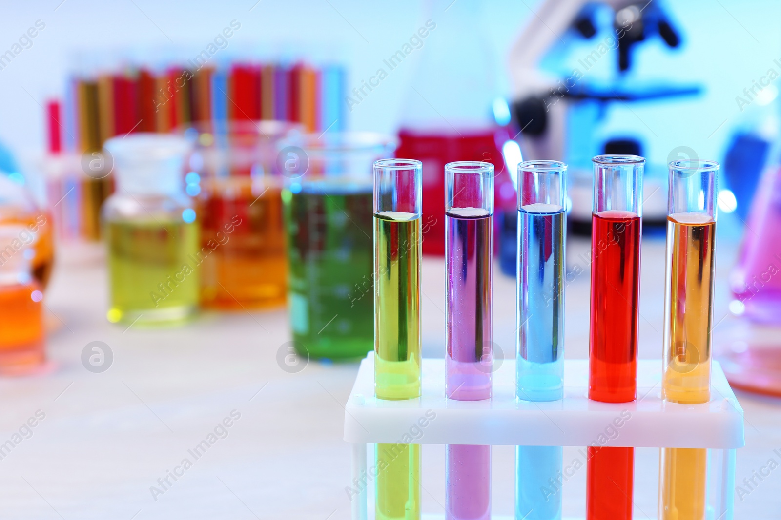 Photo of Test tubes with samples in rack on table, closeup and space for text. Solution chemistry