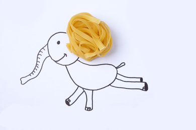 Funny elephant made with pasta on white background, top view