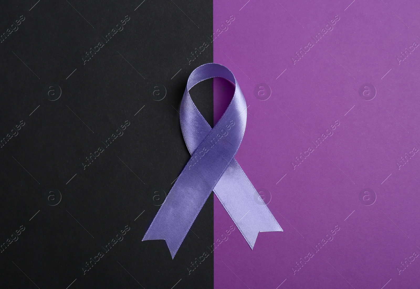 Photo of Purple awareness ribbon on color background, top view