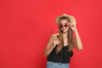 Photo of Beautiful girl with piece of watermelon on red background. Space for text