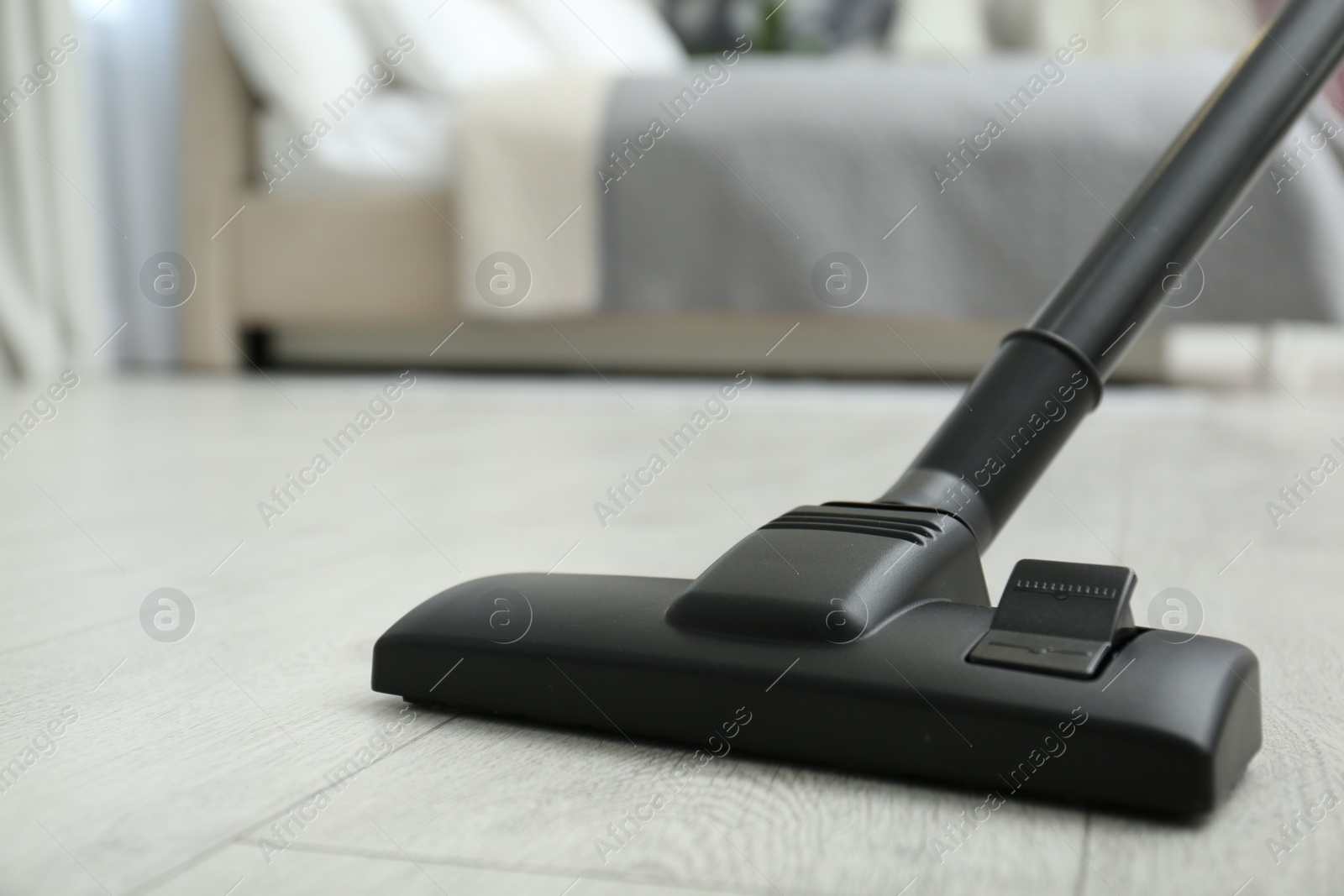 Photo of Hoovering floor with modern vacuum cleaner, closeup. Space for text