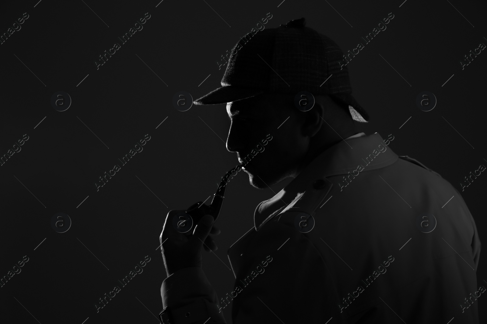 Photo of Old fashioned detective with smoking pipe on dark background, black and white effect