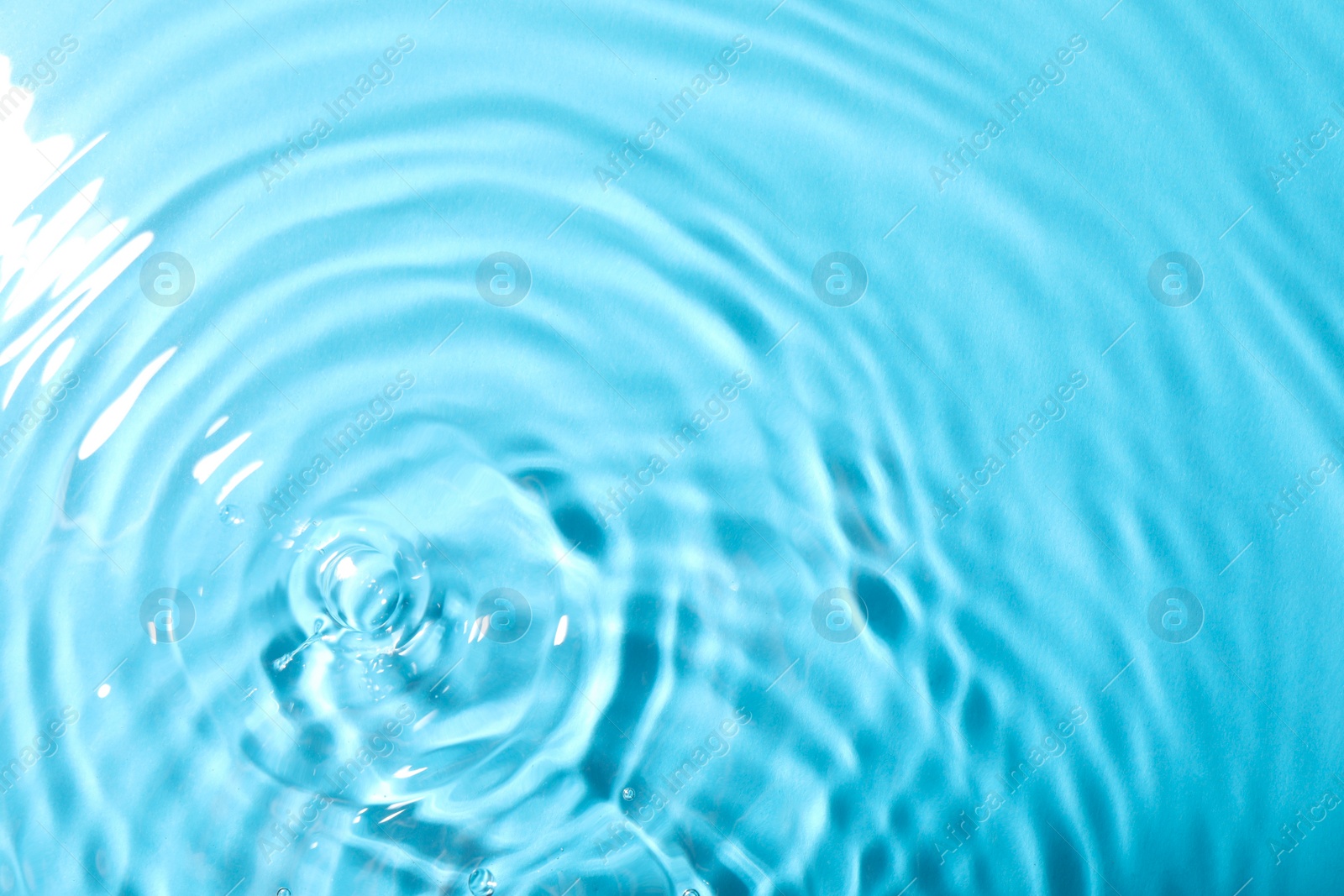 Photo of Closeup view of water with rippled surface on light blue background