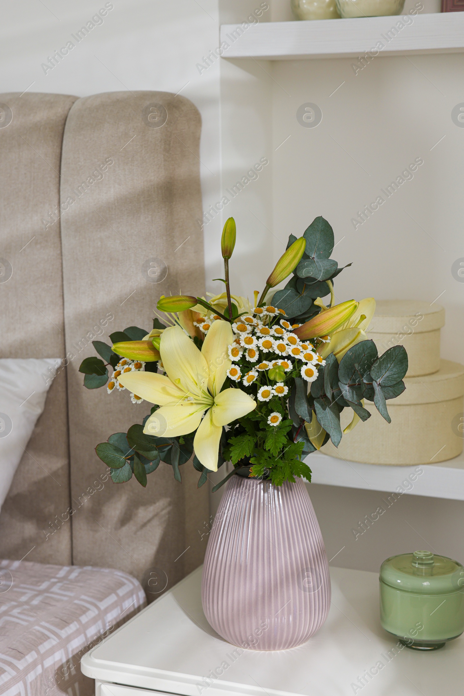 Photo of Bouquet of beautiful flowers on nightstand in bedroom