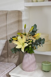 Bouquet of beautiful flowers on nightstand in bedroom