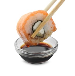 Dipping tasty sushi into soy sauce isolated on white