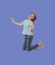 Image of Happy cute girl jumping on light blue background