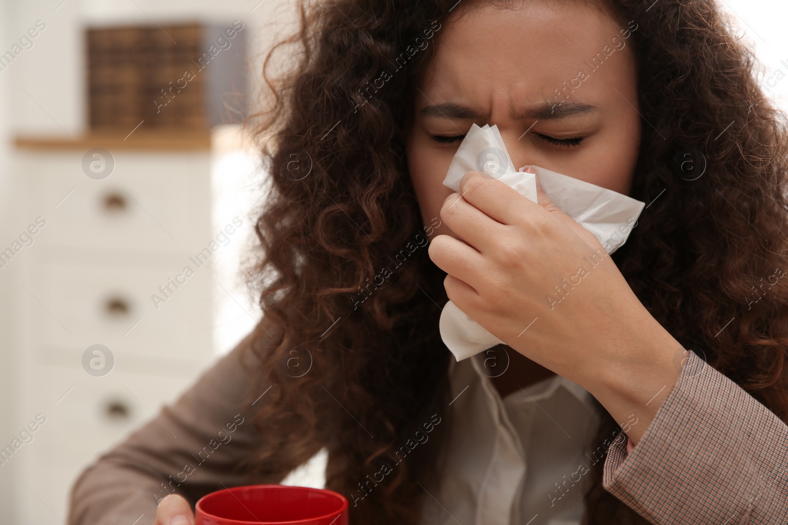 Photo of Sick African-American woman at workplace. Influenza virus