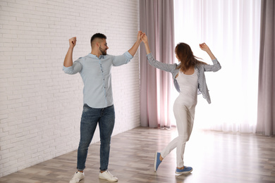 Lovely young couple dancing together at home