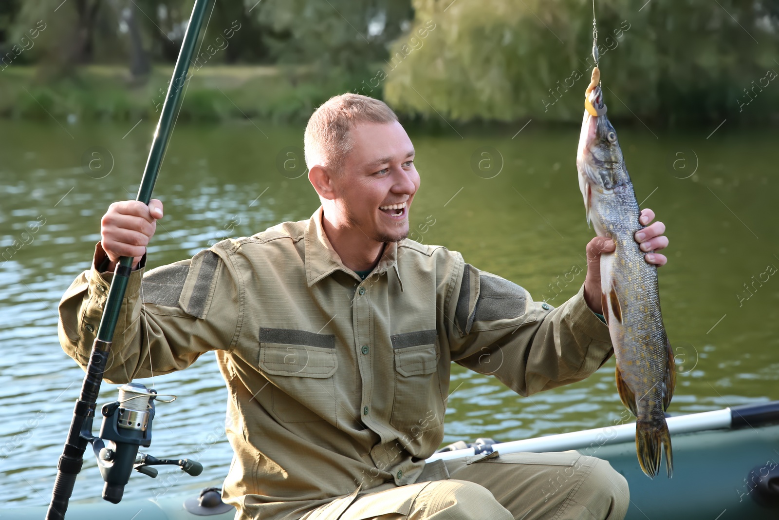 Photo of Man with rod and catch fishing from boat. Recreational activity
