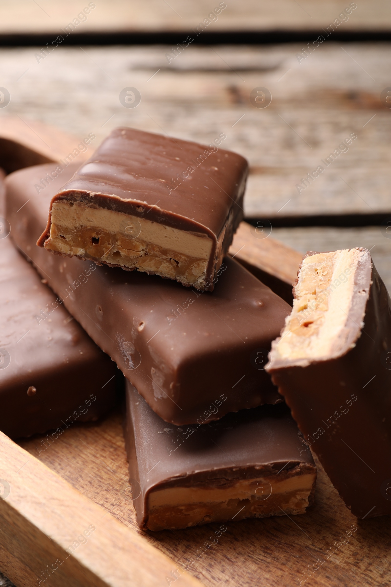 Photo of Tasty chocolate bars with nougat on table, closeup