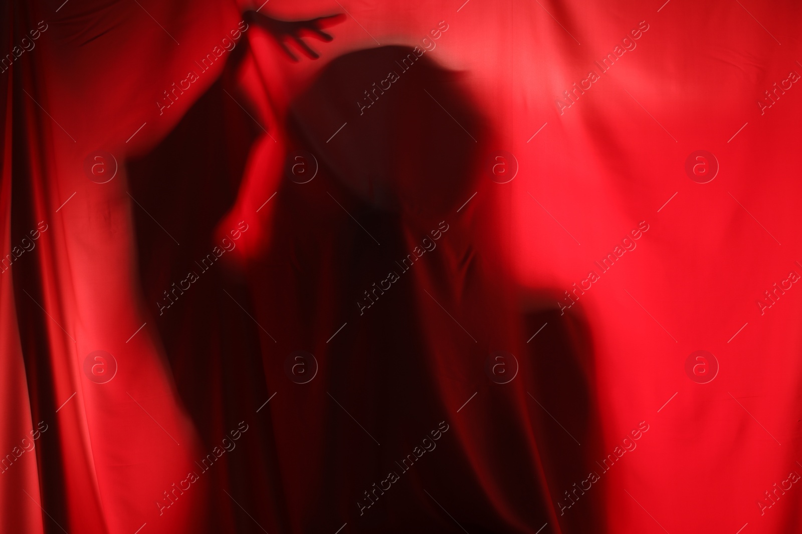 Photo of Silhouette of creepy ghost behind red cloth