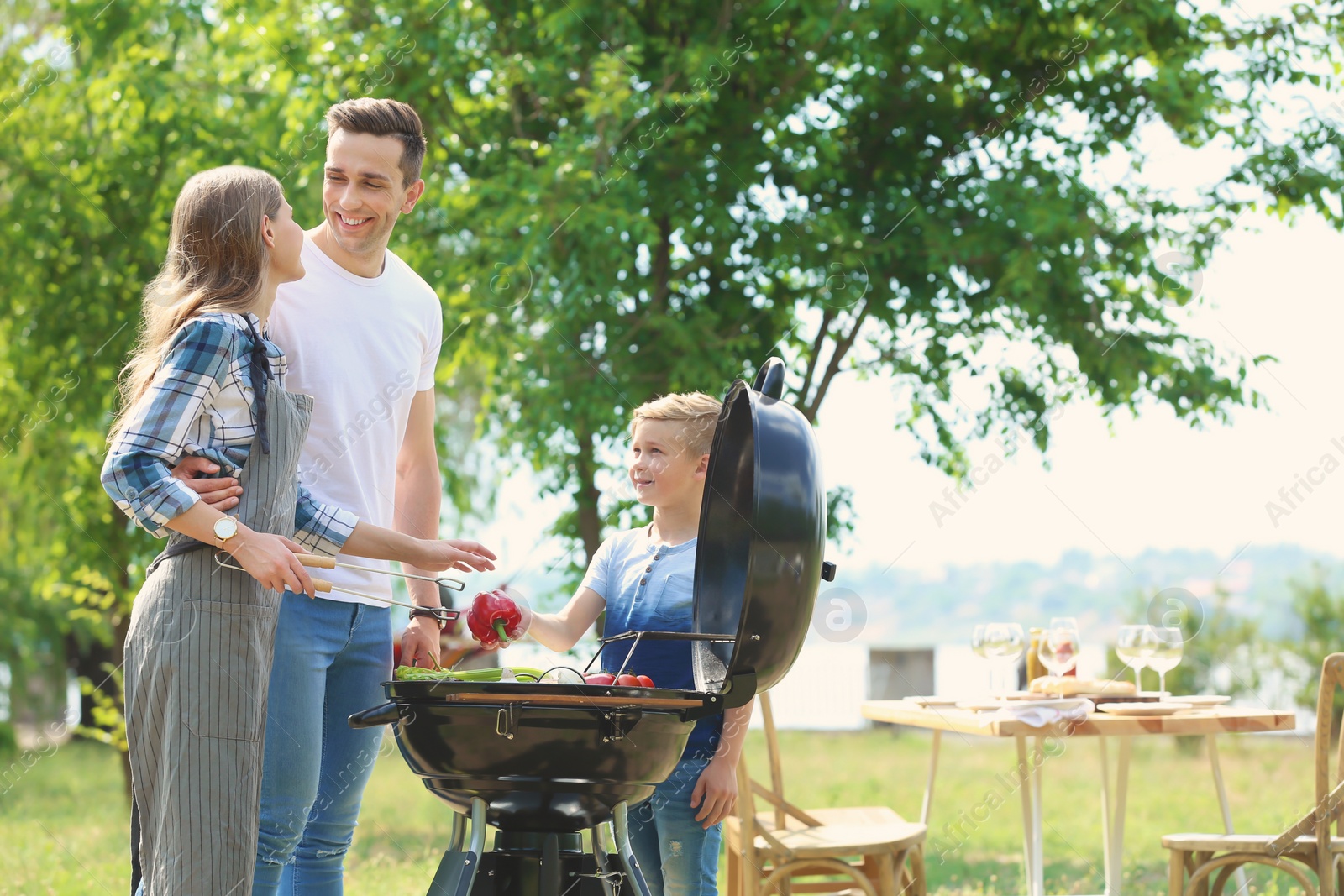 Photo of Happy family having barbecue with modern grill outdoors