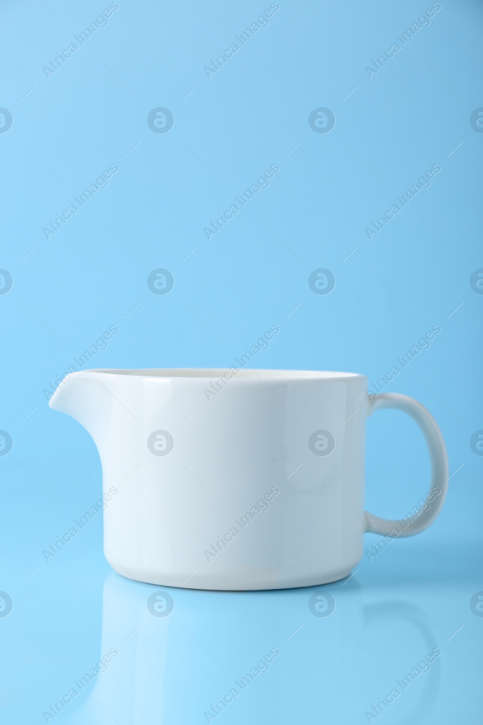 Photo of One jug on light blue background, space for text