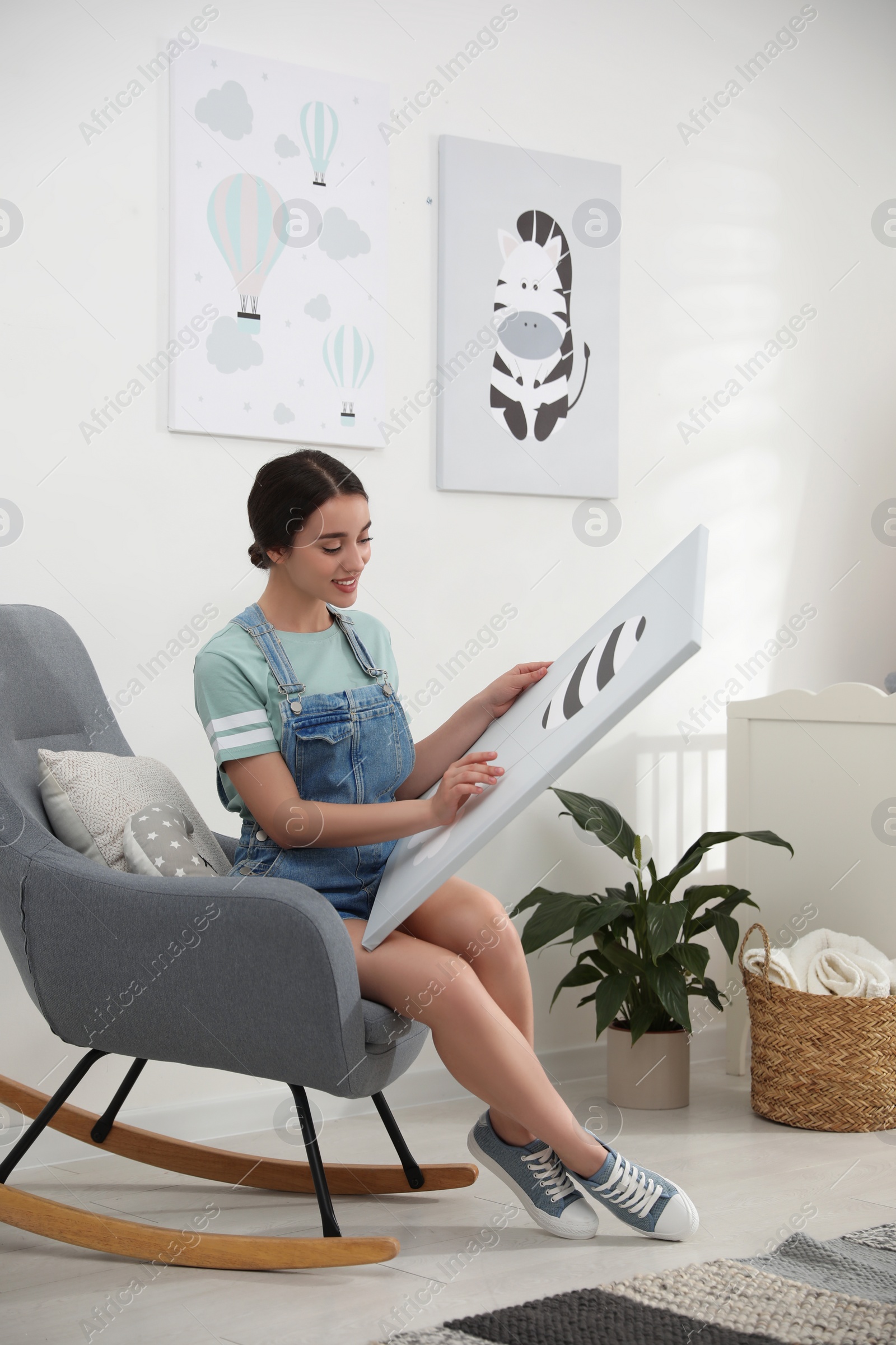 Photo of Decorator with picture sitting indoors. Children's room interior design