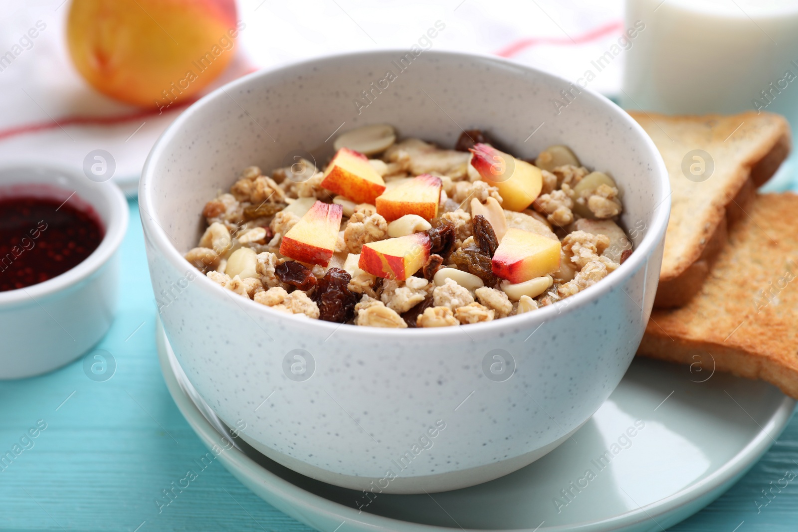 Photo of Muesli with peaches on light blue wooden table. Healthy breakfast