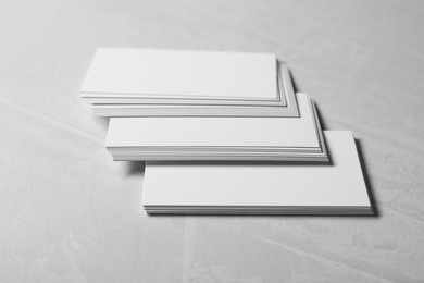 Photo of Blank business cards on light grey textured table, closeup. Mockup for design