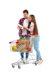 Photo of Young couple with full shopping cart on white background