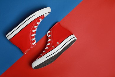 Photo of Pair of new stylish red sneakers on colorful background, flat lay