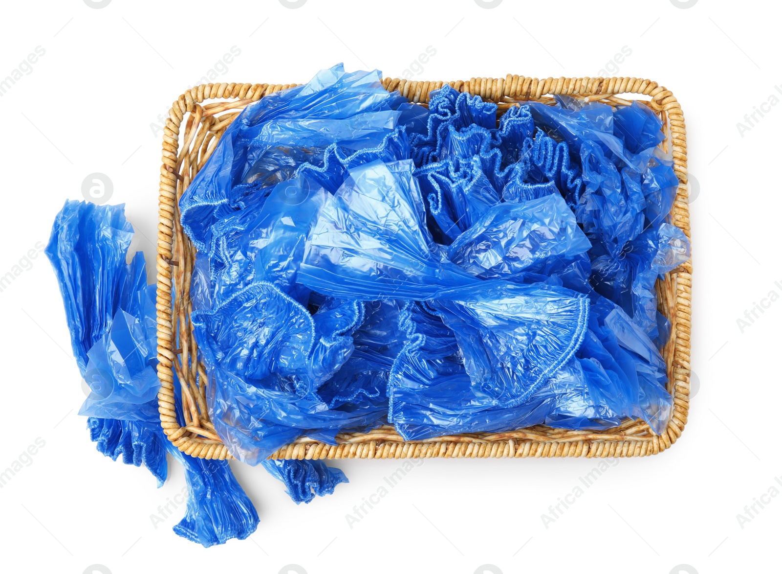 Photo of Basket with blue medical shoe covers isolated on white, top view