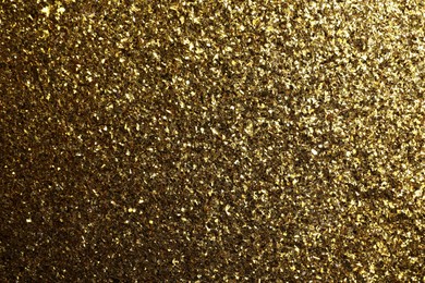 Photo of Beautiful shiny brass glitter as background, closeup