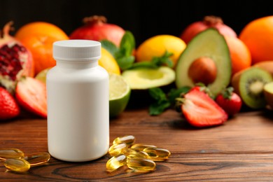 Photo of Vitamin pills, bottle and fresh fruits on wooden table. Space for text