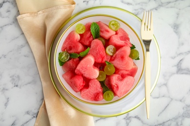 Photo of Delicious salad with watermelon on white marble table, flat lay