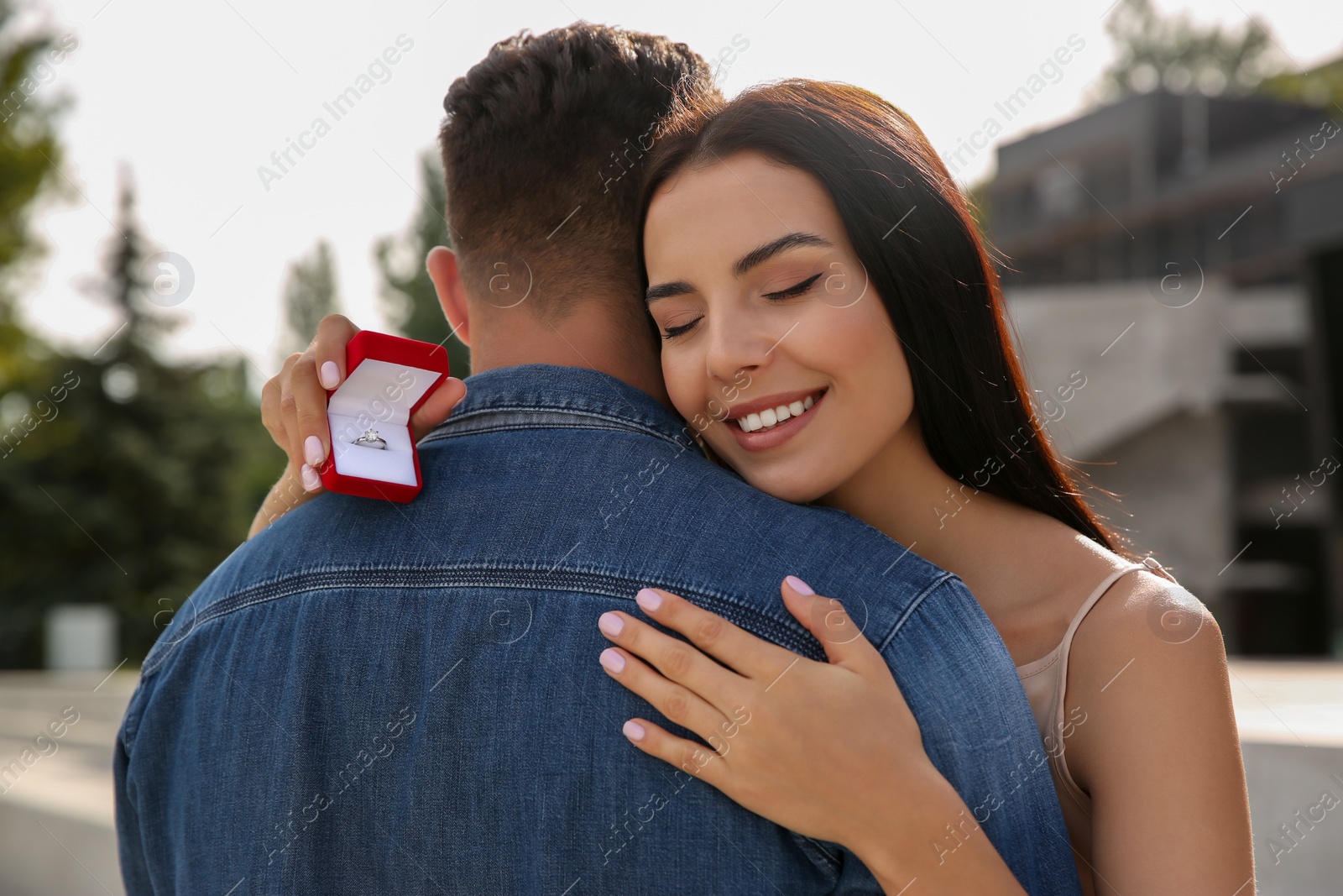 Photo of Man with engagement ring making proposal to his girlfriend outdoors