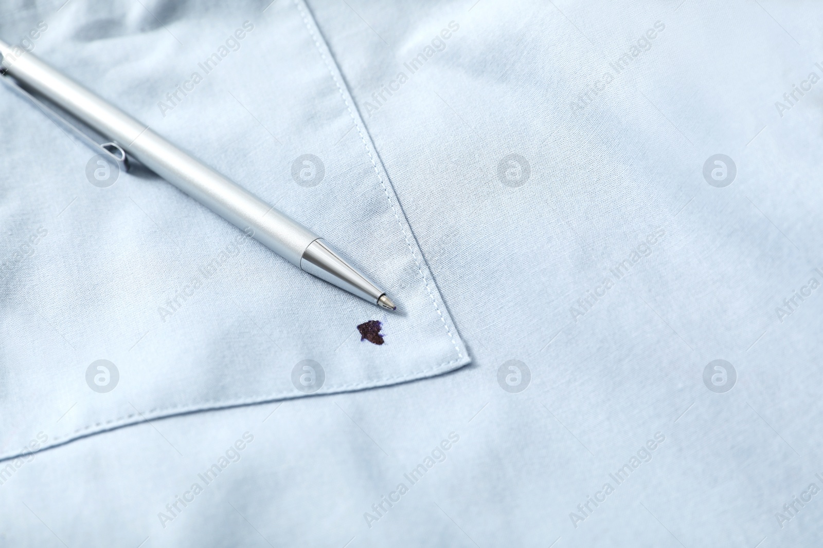 Photo of Pen and stain of black ink on light shirt, closeup. Space for text