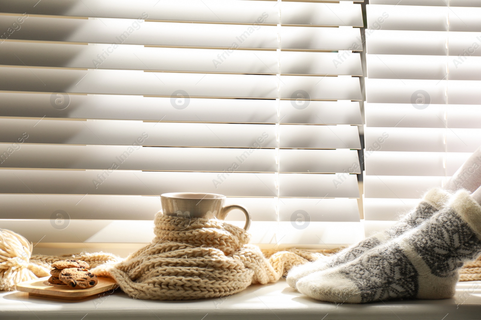 Photo of Woman and cup of hot winter drink near window indoors, closeup