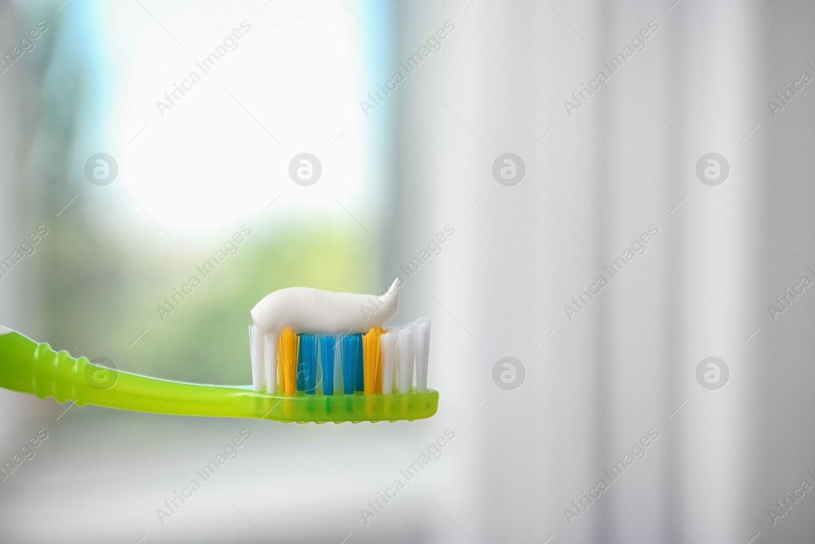 Photo of Toothbrush with paste on blurred background, closeup