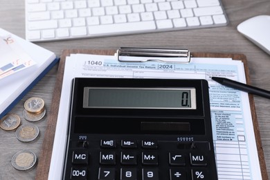 Photo of Tax accounting. Calculator, document, money, keyboard and stationery on wooden table, closeup