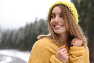 Photo of Young woman in warm clothes outdoors. Winter vacation